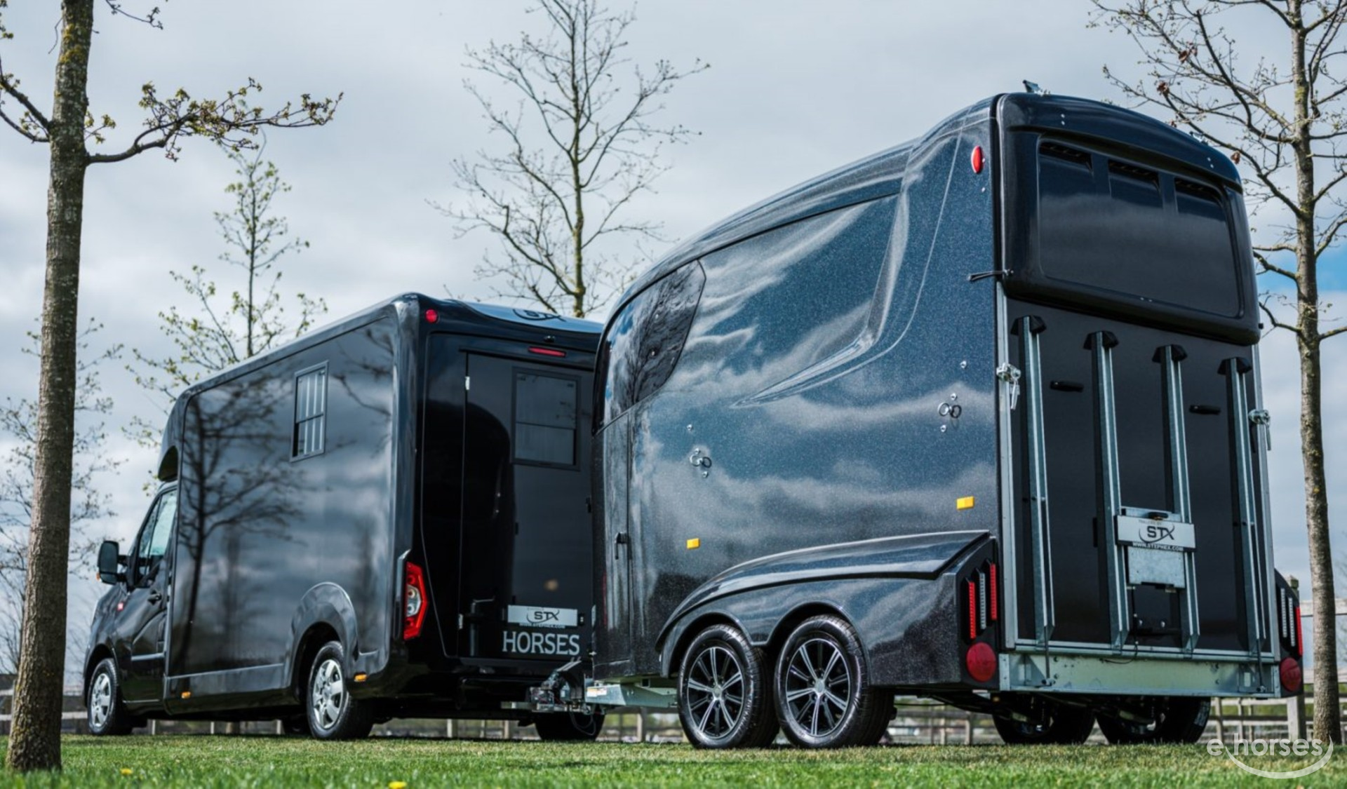 Zwarte paardentrailer gekoppeld aan een camper